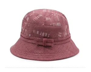 Vista laterale del cappello a secchiello bordeaux con strisce bianche e fiocco decorativo