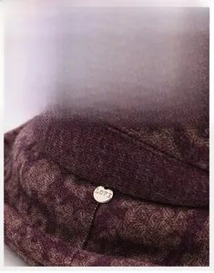 Detailed view of dark purple wool bucket hat with decorative LOVE gold metal buckle