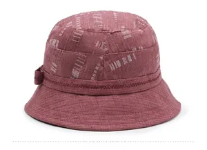 Dettaglio macro del tessuto in cotone e lino rosso scuro con motivi tratteggiati bianchi sul cappello