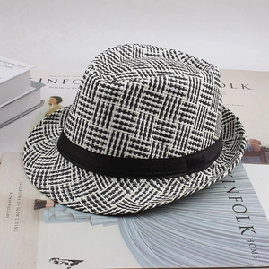 Détail d'un chapeau fedora en paille à carreaux noir et blanc avec ruban noir chic