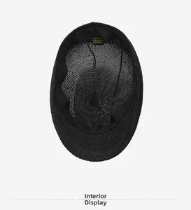 Detail view of inner black straw ivy cap showing 100% paper fiber label and mesh texture