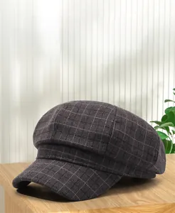 Close-up of vintage grey plaid newsboy cap on a wooden surface with a soft interior setting