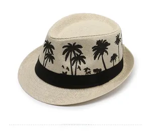 Detail of beige straw jazz hat featuring black ribbon with coconut tree embroidery motif
