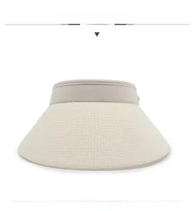 Detailed view of the woven straw texture and fabric trim on a beige sun visor hat