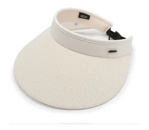 Detail of cream sun visor showing the woven texture and adjustable black buckle strap
