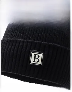Close-up of black ribbed knit beanie featuring a minimalist square patch with white B letter