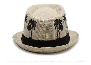 Detail view of the back of a beige Fedora straw hat with black palm tree embroidery