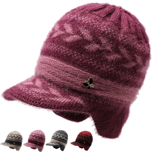 Macro detail of plush knit texture and beaded butterfly accent on winter earflap hat