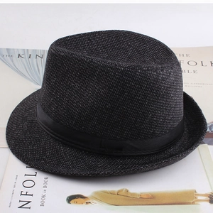 Detailed close-up of dark grey tweed plaid fedora hat with black ribbon on a magazine