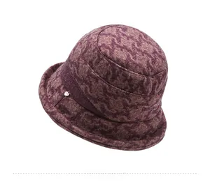 Detail view of the deep burgundy knit bucket hat featuring textured floral patterns