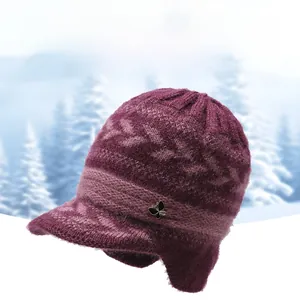 Detail of a thick purple knit hat for women featuring a metal butterfly and ear flaps