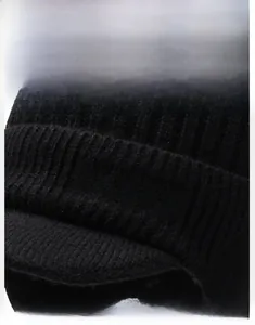 Detail of black knit beanie with visor featuring silver Sport embroidery and striped texture