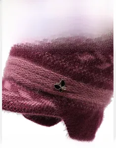 Close-up of purple knit winter hat with fuzzy mohair texture and black butterfly charm
