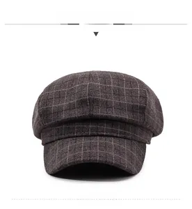 Detailed view of dark brown plaid newsboy cap featuring 8-panel wool blend texture