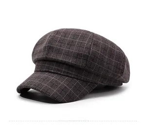 Close-up of brown plaid newsboy cap showing thick wool texture and stitching details