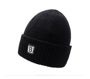 Detail of black winter beanie featuring ribbed knit texture and B-letter patch embroidery