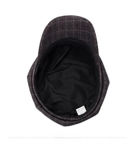 Detail of checkered newsboy cap interior showing the fabric lining and care label