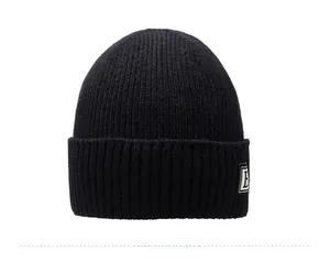 Detailed view of black ribbed knit beanie with white letter B patch for winter warmth