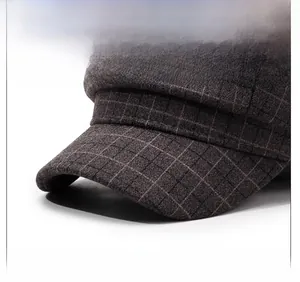 Detail of a plaid newsboy cap showing the stiff visor and wool blend fabric texture