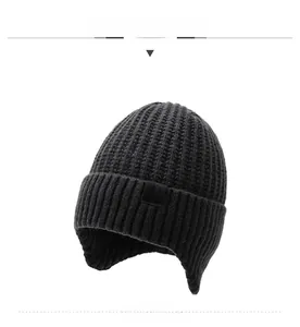 Detail of winter beanie featuring thick knit texture and snowflake patch on earflap