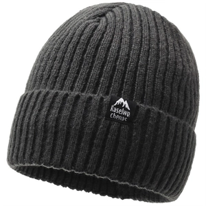 Close-up of dark grey knitted beanie with ribbed texture and woven mountain logo patch