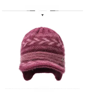 Close-up of wine red knitted winter hat with ear flaps and small metal logo detail