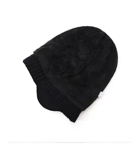 Dettaglio della spessa fodera in pile nero e del bordo a coste del berretto in maglia invernale