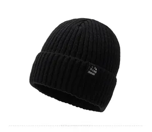 Detail of black ribbed knit beanie showing high-elastic texture and stitched logo patch