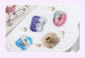Detailed view of translucent floral and butterfly wax seal stickers with gold foil accents