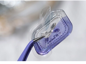 Macro shot of purple wax seal sticker with silver cutlery design and fine craft tweezers