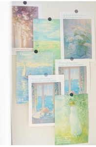 Impressionist art deco cards with floral and seascape patterns pinned to a light wall