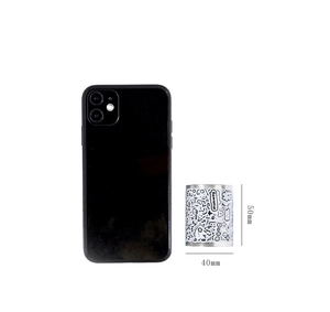 Size comparison of black and white cartoon washi tape roll next to a smartphone