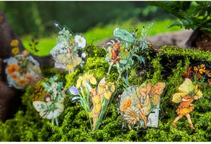 Macro detail of fairy PET stickers with holographic gold edges on green moss background