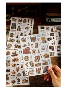 Close-up of vintage scrapbook stickers featuring retro typewriters and cameras on wood
