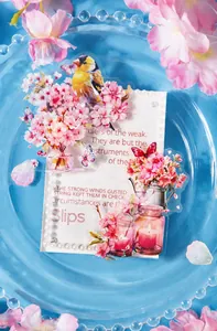 Macro shot of cherry blossom PET stickers and acrylic block with pearl border on blue glass