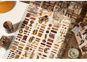 Close-up of vintage scrapbook tapes featuring retro piano and typewriter motifs on a notebook