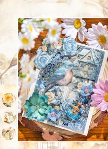 Close-up of vintage blue bird craft paper with sparkling sequins and floral details