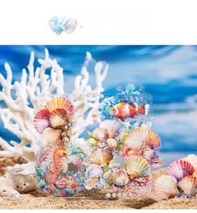 Detail of marine life acrylic stand with seahorse and shells on beach sand background