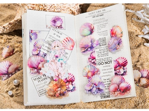 Detailed view of iridescent seashell stickers and anime girl theme on a white planner