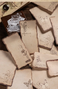 Detailed view of vintage burnt-edge paper stickers with floral patterns and butterflies