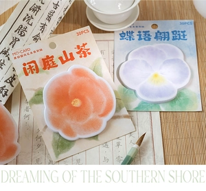 Close-up of vintage floral sticky notes with burnt edges and camellia illustrations