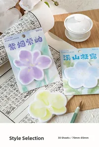 Detail of floral shaped vintage sticky notes in purple, blue and yellow with tea set décor