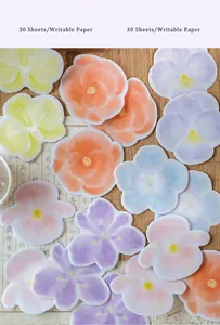 Detail of floral petal paper stickers in pastel colors on vintage calligraphy paper