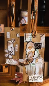 Detail of vintage collage craft tag with butterfly, lace, and brown leather rope