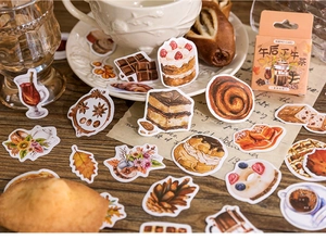 Close-up of afternoon tea theme stickers with desserts and coffee on a wooden desk