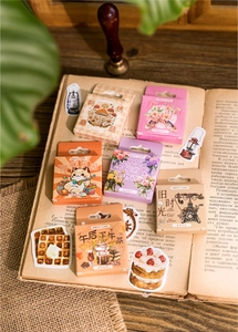 Six boxes of vintage floral stickers displayed on old books with a nostalgic aesthetic
