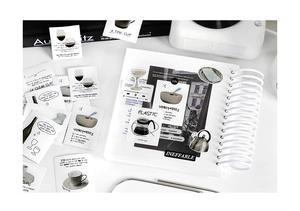 Flat lay of minimalist art stickers featuring coffee and food illustrations on a notebook
