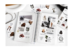 Detail shot of vintage lifestyle stickers and a spiral journal on a clean white table