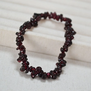 Détail macro d'un bracelet élastique en grenat avec pierres polies rouge foncé