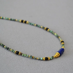 Détail du collier artisanal perlé en turquoise et lapis-lazuli avec accents dorés
